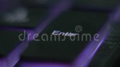 手指按下键进入计算机键盘。 带有<strong>紫光</strong>的英文键盘。 键盘，黑客，霓虹灯